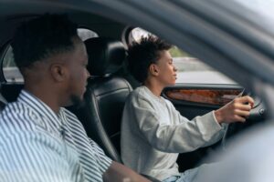 Father teaching son how to drive a car